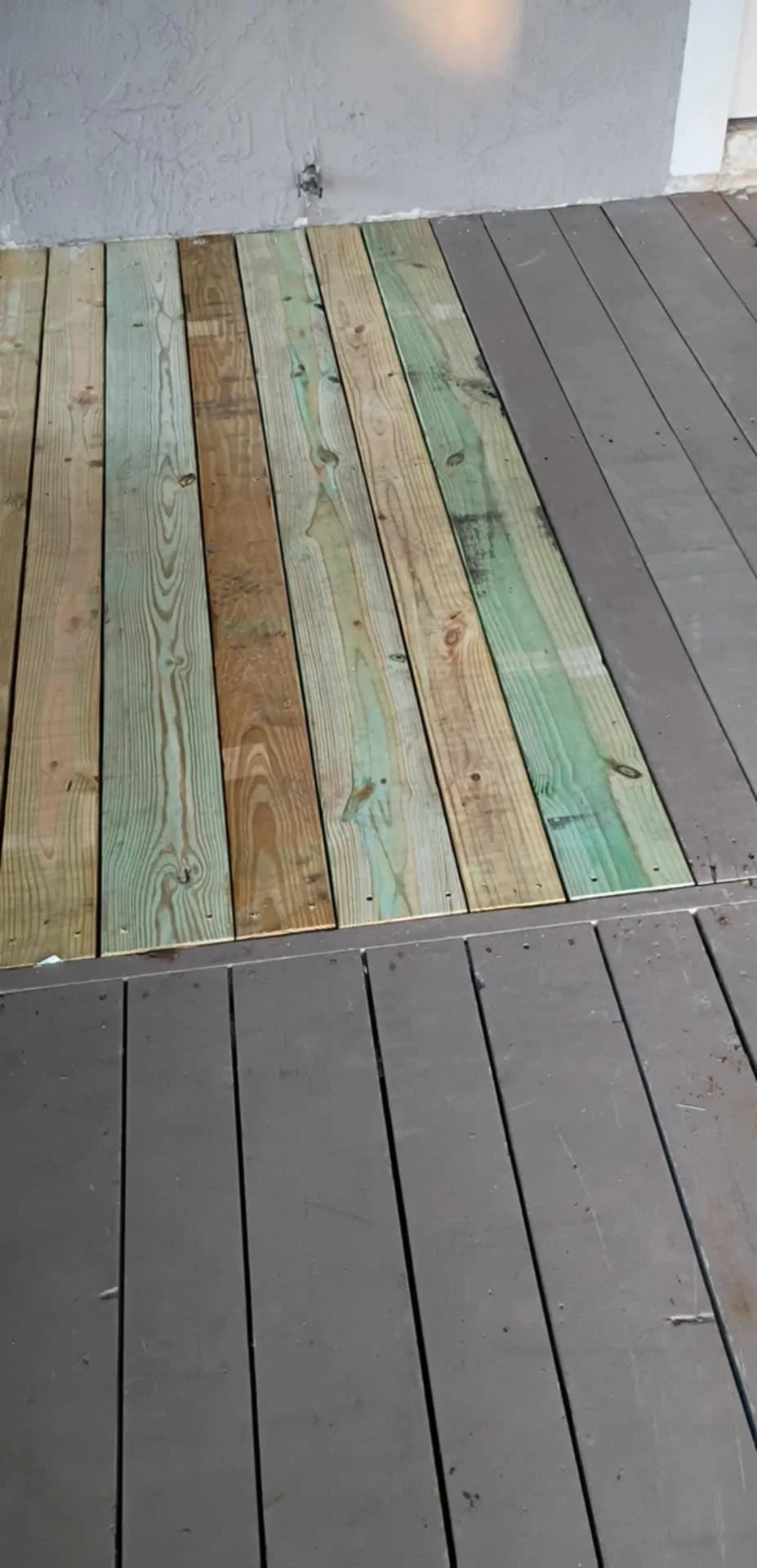 New pressure-treated deck boards installed on an exterior home deck